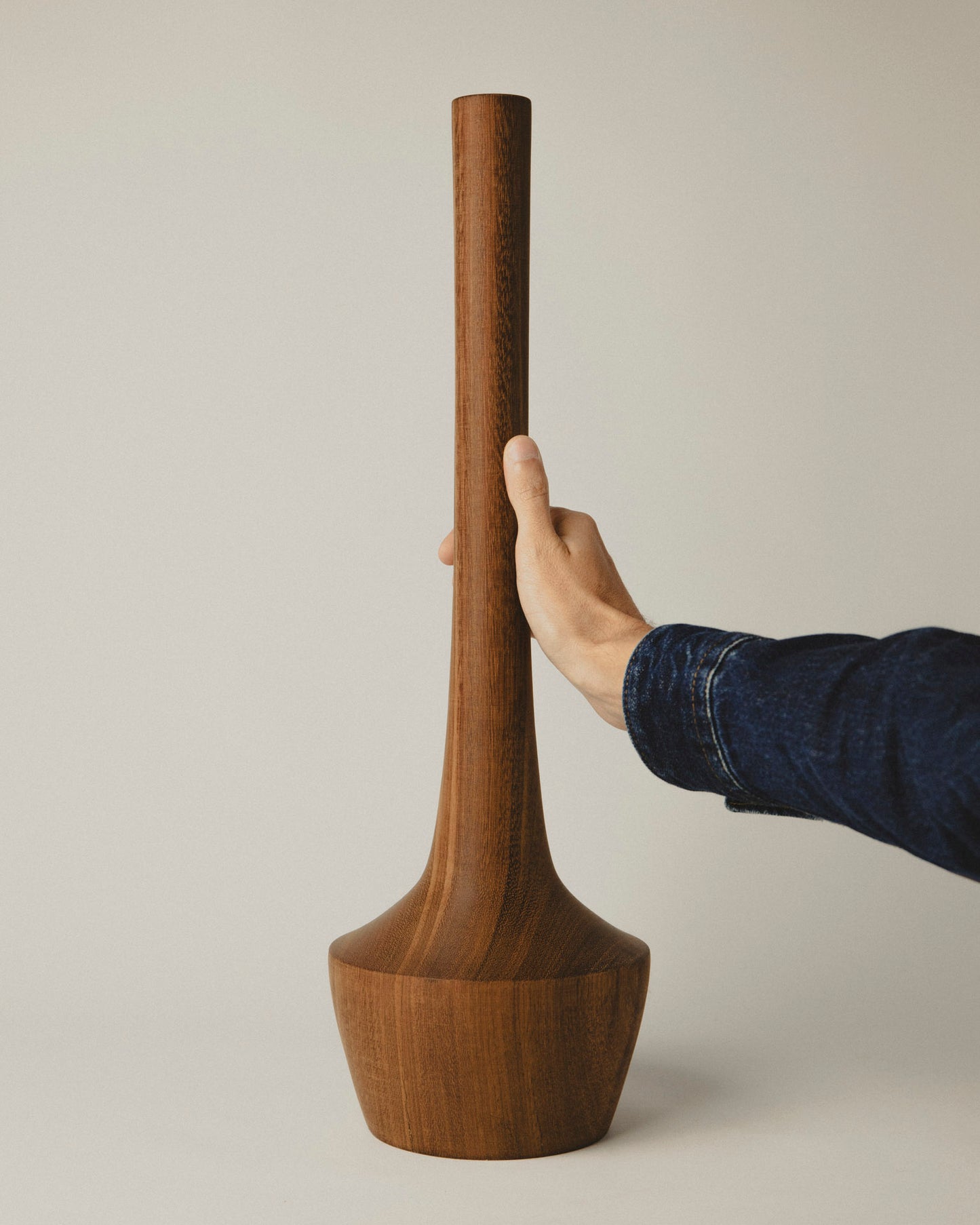 Jarrón de autor en madera de iroko, líneas limpias y robustas. Modelo 03. Foto con mano