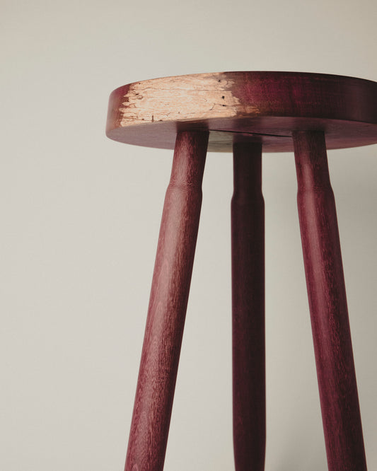 Tall stool in purpleheart wood, front view. Made by Yubero Torno.