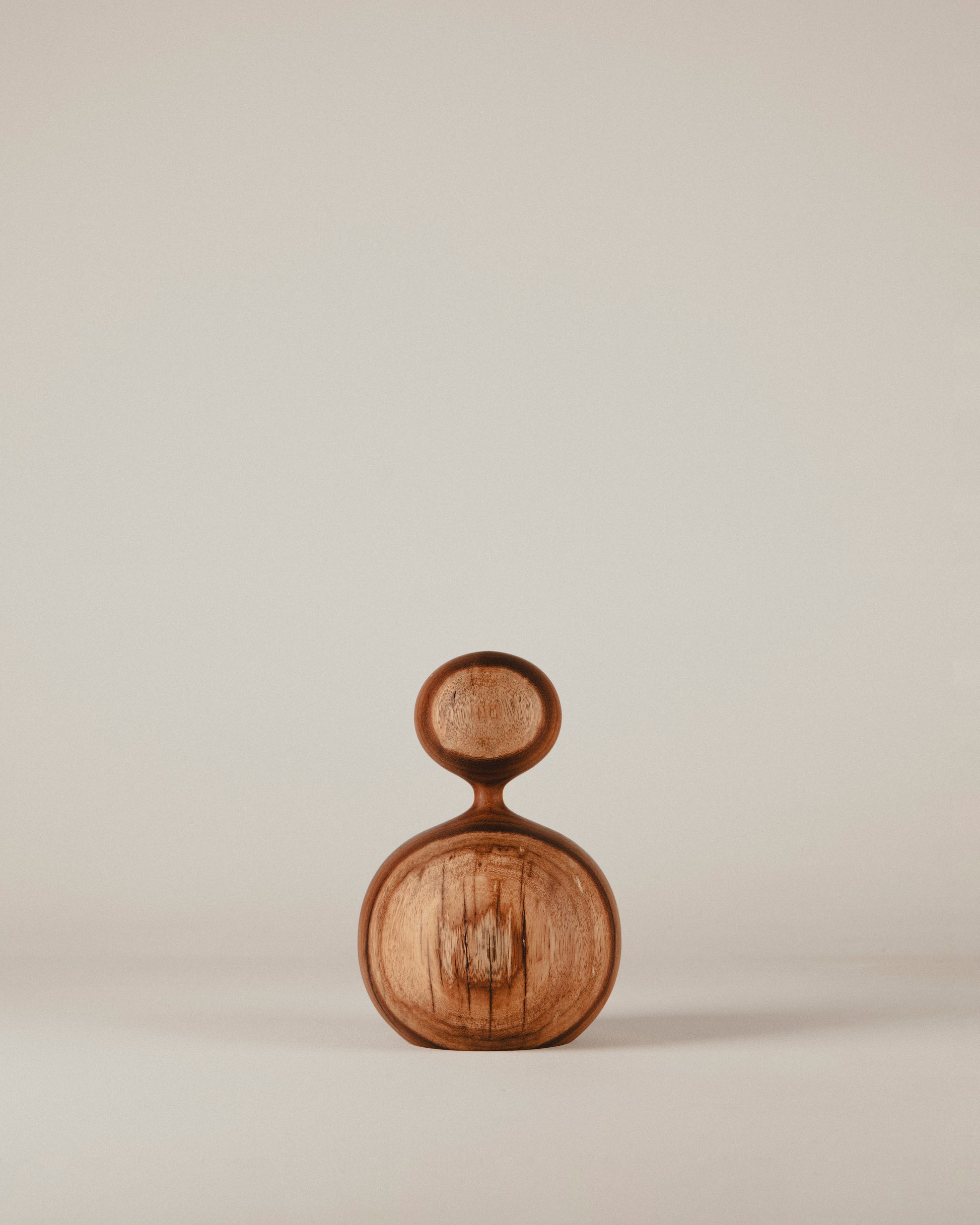 Vista frontal de la escultura de iroko Nº 07, forma compacta y curva generosa. Hecho por Yubero Torno.