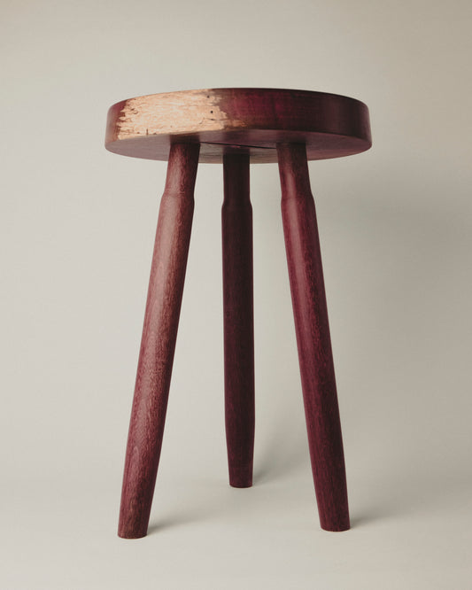 Tall stool in purpleheart wood, front view. Made by Yubero Torno.