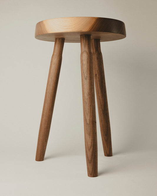 Tall stool in walnut wood, front view. Made by Yubero Torno.